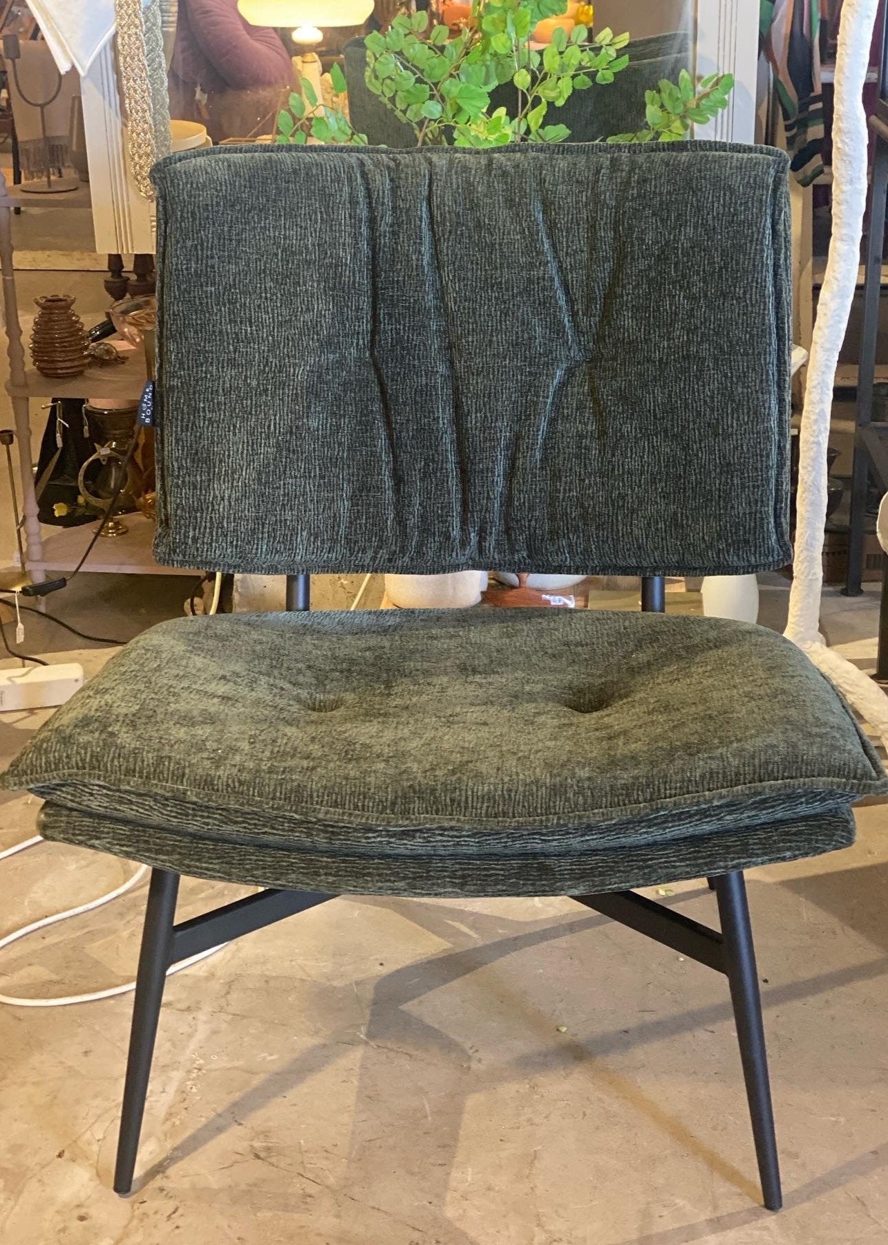 Fauteuil in stof groen met mat zwart metalen onderstel.